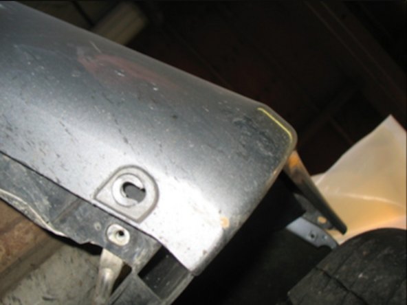 From underneath remove the 2 screws holding the very bottom edge of the bumper.