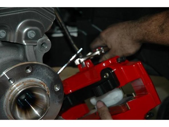 Tighten the brake line on the caliper first and find something to hang it. Here some pictures putting the BBK on.