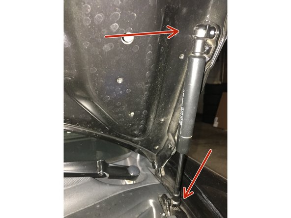 Using a small flat head screw driver , pry open metal clips on the top and bottom of strut