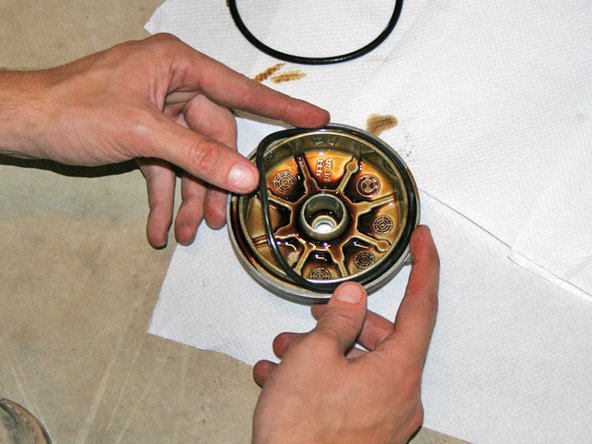 Change the washer at the top of the oil filter housing bolt. Change the rubber O-ring on the oil filter housing cap. Provide the new O-ring a light coating of fresh oil.