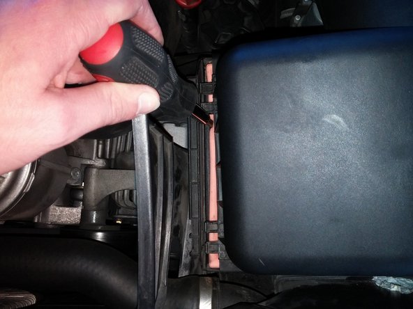 To put the lid back in place, press down on the left side of the lid and pull up slightly on the right side while sliding the hooks back into the holes.