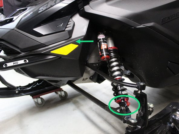 Lift the front of the snowmobile in such a way that the skis are off the ground.