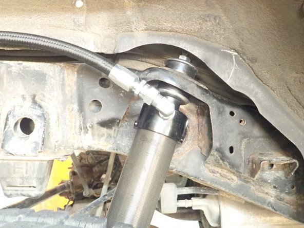 Install lower mount first, then compress shock to slide upper stud in place. Must have 1 isolator Under and 1 over the shocks mounting.