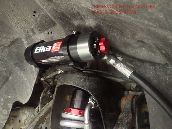 Sit the reservoir centered into the bracket clamps, then place the reservoir in such a way as to place the hose properly. BE CAREFUL TO NOT OVERBEND THE HOSE OR CREATE RUBBING ON FRAME OR UCA.