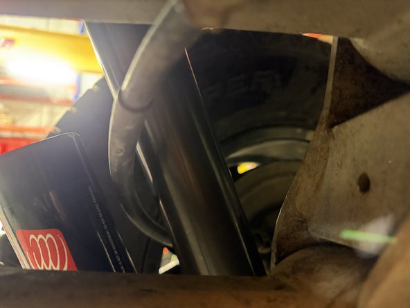Install the longer spacer on the rear right side as shown to offset the handbrake cable. Make sure that the cable does not touch the reservoir.
