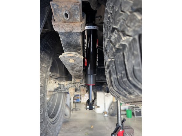 Both sides : Install the rear shock with the reservoir facing the rear of the vehicle.Using