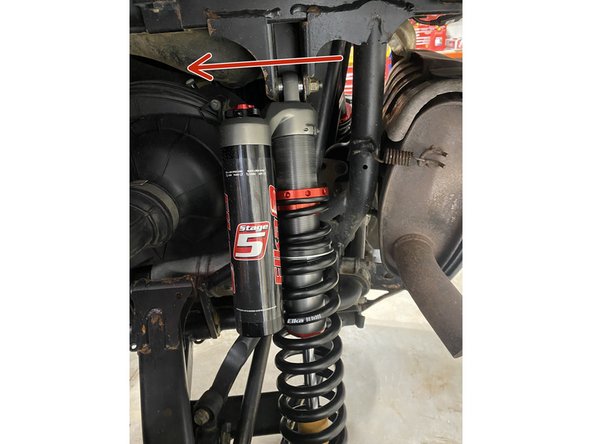 Install the left and right new Elka rear shock with the piggyback reservoir at the top and oriented towards the front of the vehicle as indicated by the red Arrow on the photo.