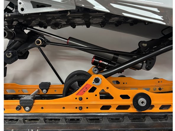 Install the Elka rear shock with the reservoir at the bottom and oriented towards the front of the snowmobile as shown on the photo.