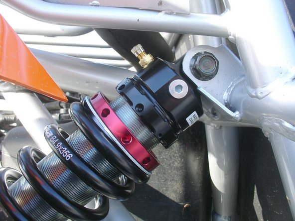 INSTALL SHOCKS WITH THE SCHRAEDER VALVE AT THE TOP AND TOWARDS THE BACK OF THE VEHICLE.