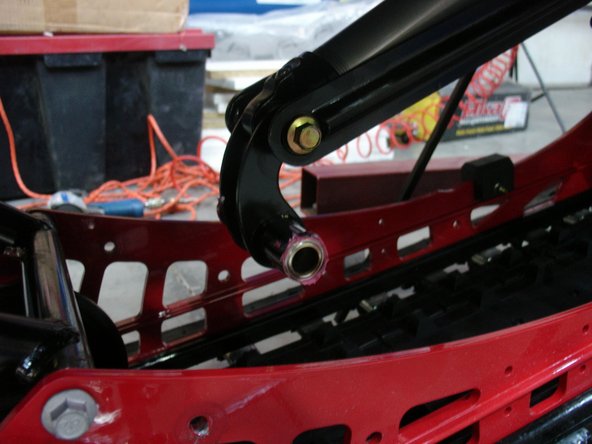 Remove central idler wheels assy to have access to lower rear shock bolt. Keep all the OEM hardware to install Elka rear shock.