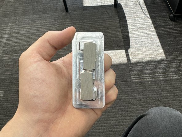 Insert the hardware inside the hole. Make sure the two studs are aligned as in the picture