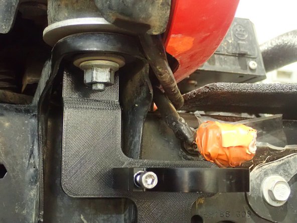 Remove nut that hold the front cab support, then install reservoir bracket as shown. ( Right side shown)