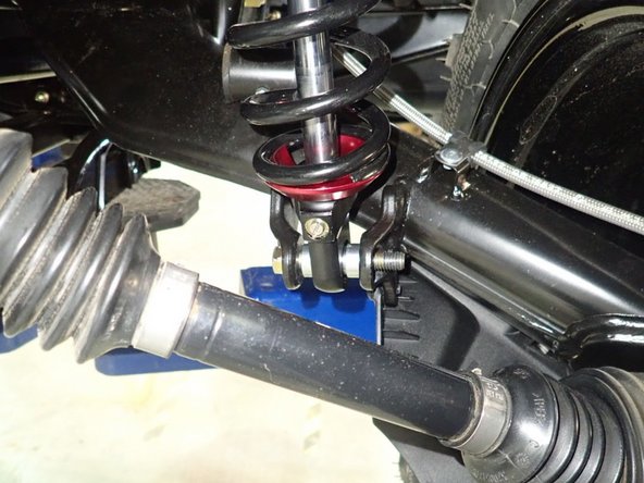 On Stage 2, Stage 4, and Stage 5 models the rebound adjuster located on lower eyelet of the shocks should be oriented towards the rear of the vehicle, as shown. (Right side shown ). If needed, you can turn the lower eyelet to orient properly.