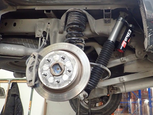 Install rear shocks with head up as shown. (Right side shown)