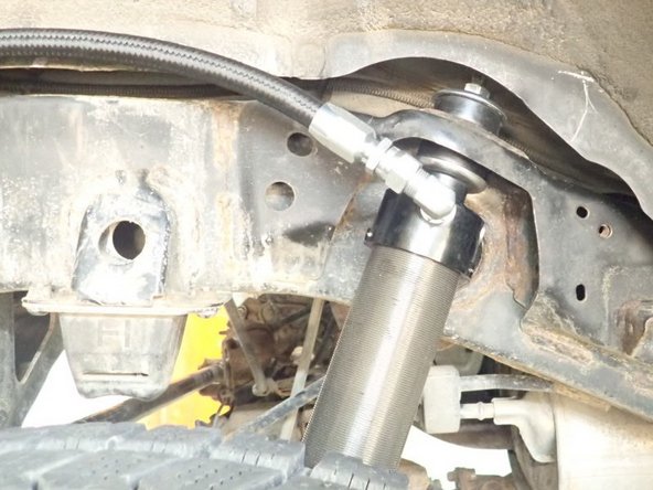 Install lower mount first, then compress shock to slide upper stud in place. Must have 1 isolator under and 1 over the shock mounting.