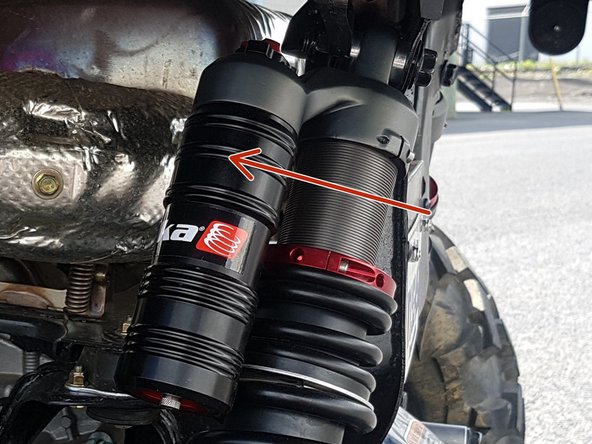 Install the left and right new Elka rear shock with the piggyback reservoir at the top and oriented towards the front of the vehicle as indicated by the red Arrow on the photo. On Stage 1 and Stage 2, the left and the right shock are the same. Just install them with the shraeder nitrogen valve at the top of vehicle.
