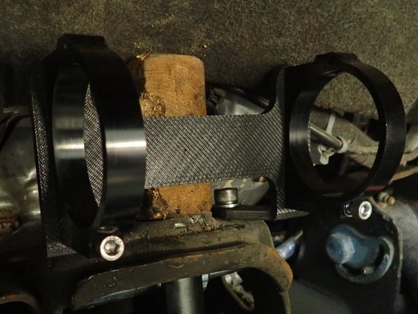 Align reservoir bracket with the 2 upper mount holes. You will have to push and hold or cut fender guard to allow space for bracket.