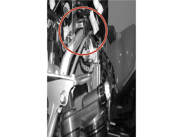 Route the reservoir’s hose underneath the radiator mounting bracket.