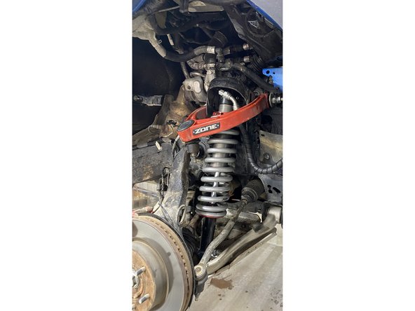 Make sure that the flat of the lower pin is against lower arm, as shown.