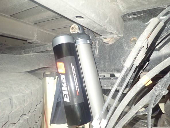 ON REAR LEFT SIDE: install shock with reservoir facing Inside the vehicle as shown.