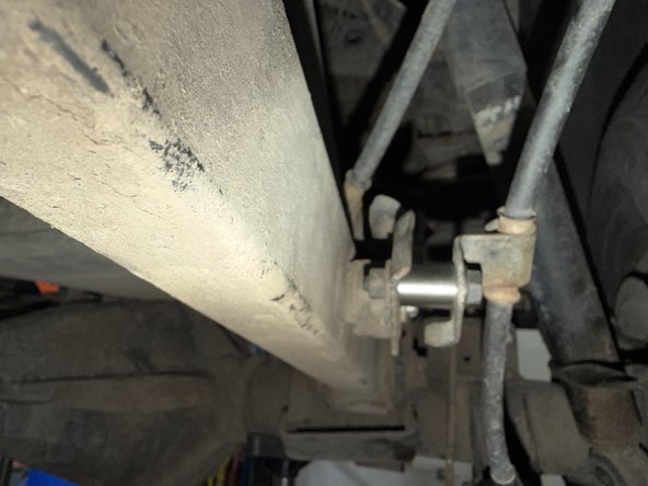 Install the longer spacer on the rear left side as shown to offset the handbrake cable. Make sure that the cable does not touch the reservoir. Use the provided bolt.
