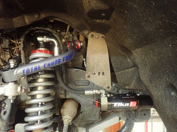 Sit the reservoir into the bracket's clamps, then place the reservoir in a way to position the hose properly. BE CAREFUL TO NOT OVERBEND THE HOSE OR CREATE RUBBING ON THE FRAME OR UCA.