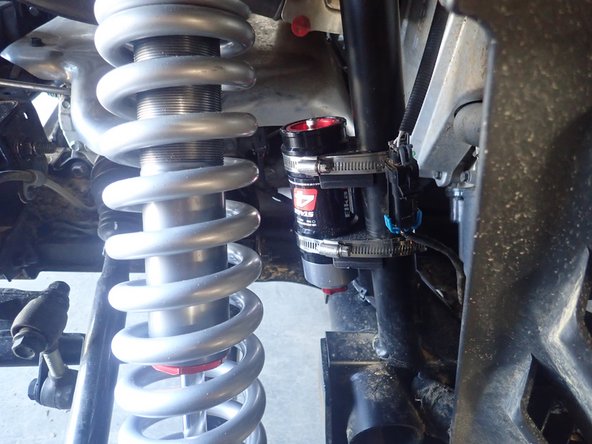 ON THE RIGHT SIDE: When installed on vehicle with the shock head up: the the fitting on the head is facing the center of the vehicle as indicated by the blue arrow.