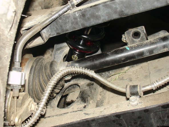 On Stage 2, Stage 4, and Stage 5 models the rebound adjuster located on lower eyelet of the shocks should be oriented towards the rear of the vehicle, as shown. (Left side shown ). If needed, you can turn the lower eyelet to orient properly.