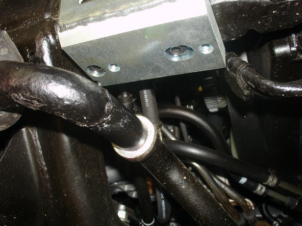 With the longer supplied bolts, and using the counter bore holes, fix the reservoir bracket in the sway bar mounting holes (right side shown).