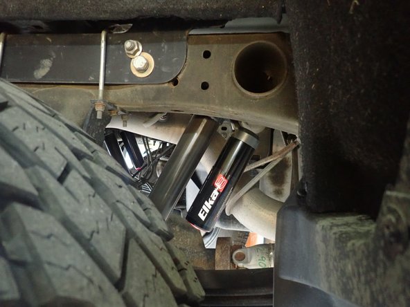 RIGHT SIDE: Install rear right shock with head to the top and reservoir facing front of vehicle as shown.