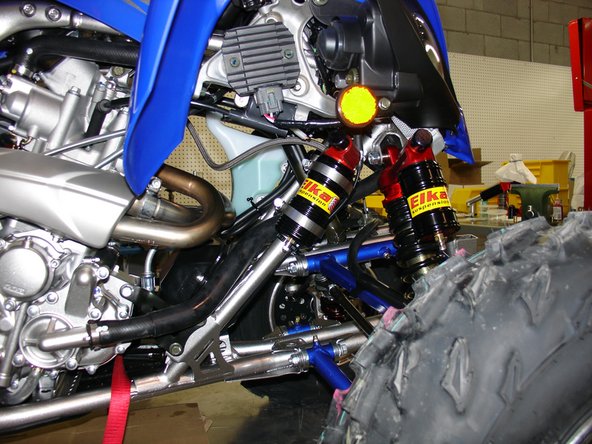 Pass the reservoir in front of the head pipes to locate the reservoir on the right side as shown. Fix reservoir with rubber isolators and worm-drive clamps.