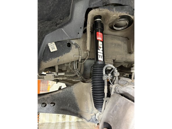 Install new Elka front shocks using lower OEM bolt. (Right side shown)