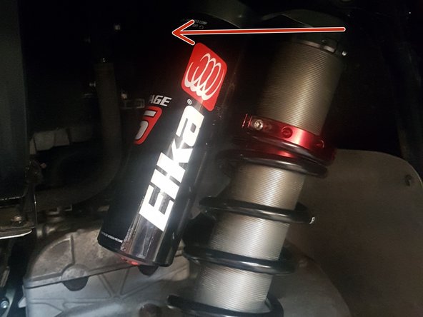Install the left and right new Elka rear shock with the piggyback reservoir at the top and oriented towards the rear of the vehicle as indicated by the red Arrow on the photo.