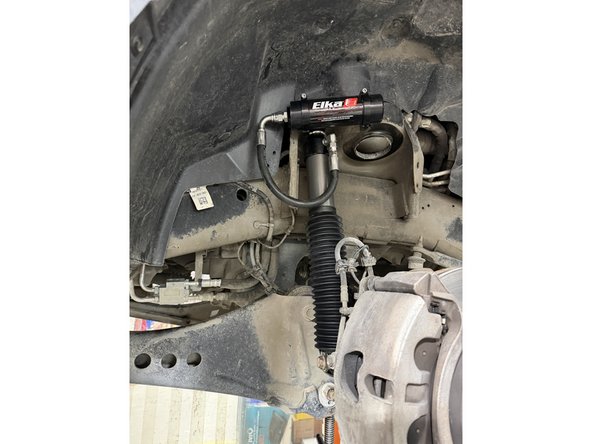 Install the second rubber bushing, followed by the washer then install the provided nut (for non-remote models).