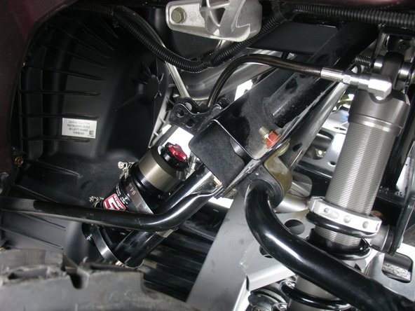 With the supplied rubber mount assembly, attach the reservoir on the frame as shown.  Note the rubber part is placed between the frame and the reservoir.