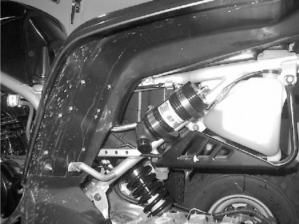 The rear reservoir must be attached to the rear sub-frame on the left side of the quad, right underneath the fender. Compression knob must face towards the side of the quad.