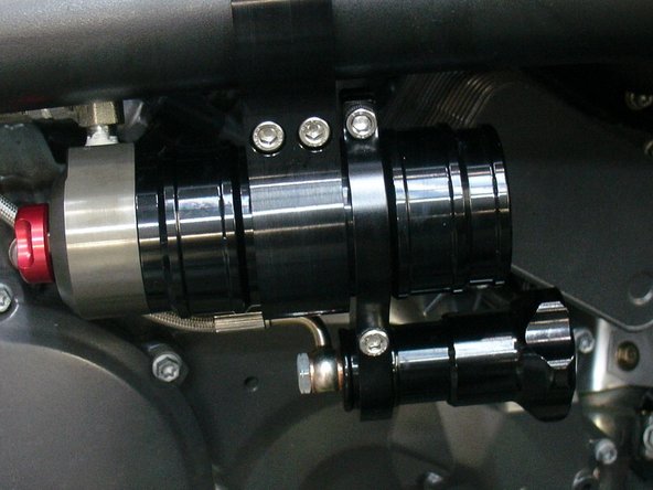 Place the hydraulic preload adujster bracket just beside reservoir bracket. Clamp the hydraulic preload adjuster close the the hose banjo. Place it carefully and torque the 2 bolts at 10 ft/pnds