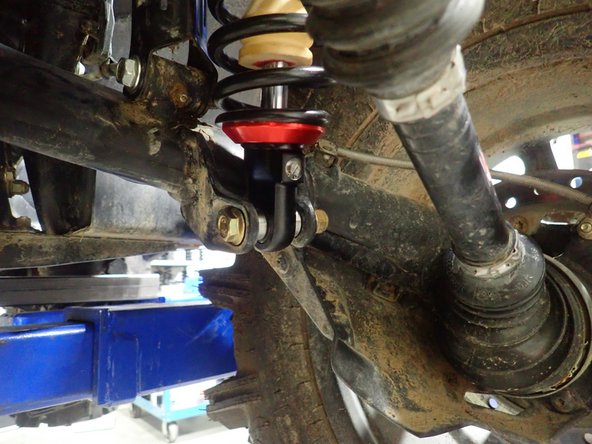 On Stage 2, Stage 4, and Stage 5 models the rebound adjuster located on lower eyelet of the shocks should be oriented towards the rear of the vehicle, as shown. (Right side shown ). If needed, you can turn the lower eyelet to orient properly.