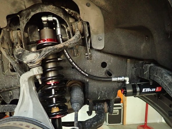 Install new Elka shocks with the upper hose fitting facing front of vehicle (passenger side shown)