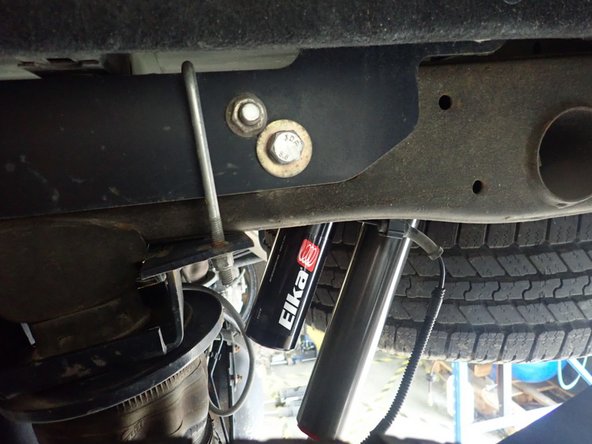 LEFT SIDE: Install rear left shock with head to the top and reservoir facing front of vehicle as shown.