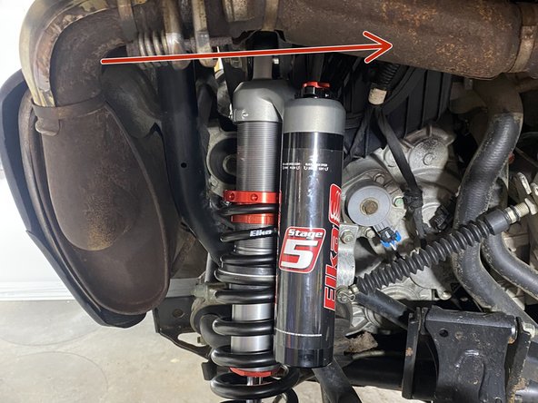 Install the left and right new Elka rear shock with the piggyback reservoir at the top and oriented towards the front of the vehicle as indicated by the red Arrow on the photo.