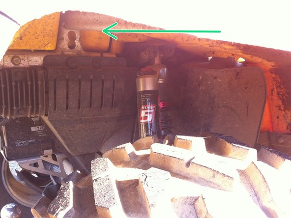 Install the right new Elka rear shock with the piggyback reservoir at the top and oriented towards the rear of the vehicle as indicated by the green Arrow on the photo.