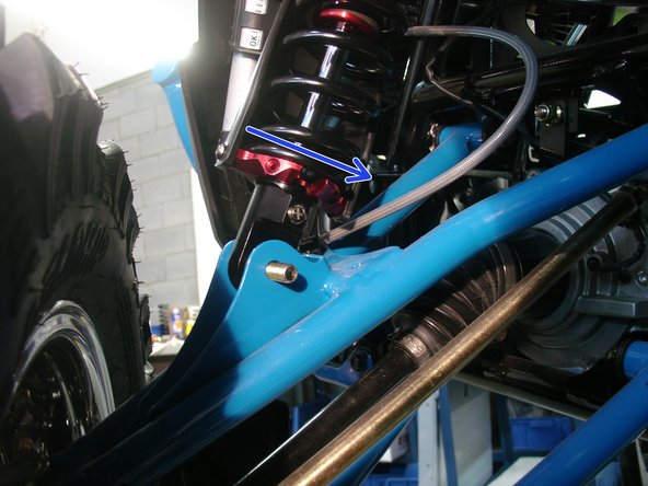On Stage 2, Stage 4 and Stage 5 models, the lower shock eyelets should be installed with the rebound adjuster oriented towards the rear of the vehicle as shown by the blue Arrow on the photo ( left side shown ). If needed, you can turn the lower eyelet to orient properly.