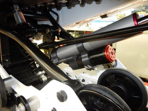 Install the Elka rear shock with the reservoir at the bottom and oriented towards the rear of the snowmobile as shown on the photo.