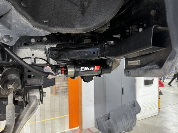 Sit the reservoir into the bracket clamps, then place the reservoir in such a way as to place the hose properly. BE CAREFUL TO NOT OVERBEND THE HOSE OR CREATE RUBBING ON FRAME.