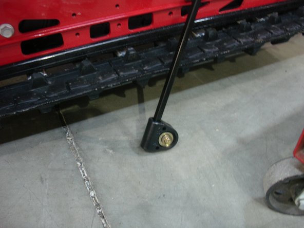 Remove central idler wheels assy to have access to lower rear shock bolt. Keep all the OEM hardware to install Elka rear shock.