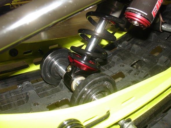 The lower shock eyelet rebound adjuster screw must be oriented toward the rear of vehicle, and the piggyback reservoir must be installed toward the right of vehicle as shown.