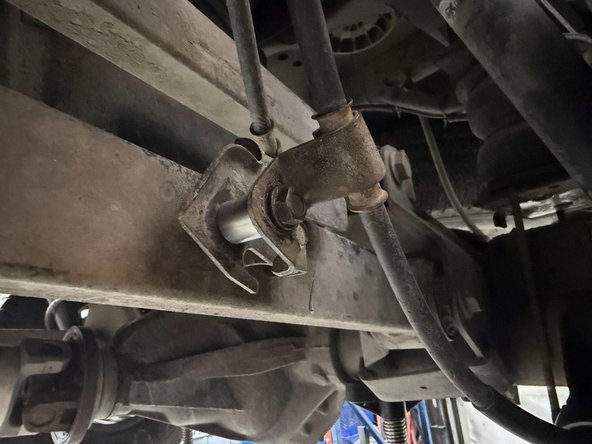 Install the longer spacer on the rear left side as shown to offset the handbrake cable. Make sure that the cable does not touch the reservoir. Use the provided bolt.