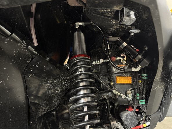 Install front shock with the hose fitting facing the front of the vehicle.