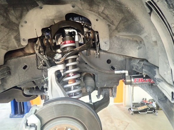 Install upper arm nut, tie rod end, swaybar link, and brake lines bolts.